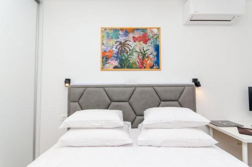een slaapkamer met een bed en een schilderij aan de muur bij Modern living apartment Airy in Split