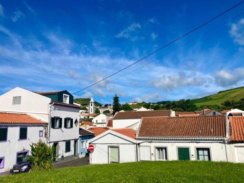 a village with white houses and a blue sky at Alojamento confortável a 2 min da Praia in Horta
