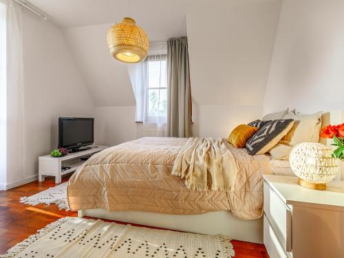ザコパネにあるVisitZakopane - Widokowy Apartmentの白いベッドルーム(ベッド1台、テレビ付)