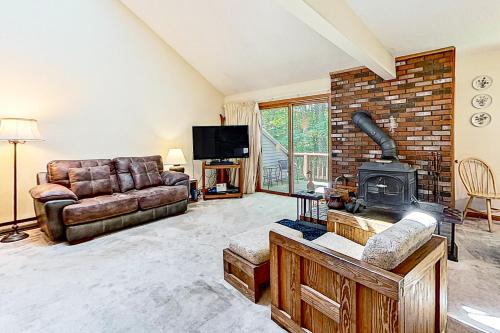 a living room with a couch and a fireplace at White Mountain Hideaway in North Conway