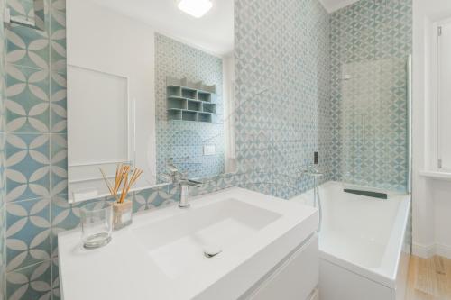 bagno con lavandino bianco e piastrelle blu di A Casa di Massi - Goelba a Portoferraio