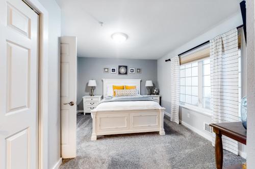 1 dormitorio con cama blanca y ventana en Surf's Up en Westport