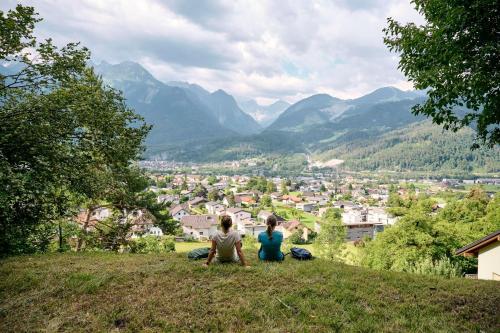 two people sitting on a hill looking at a city at my Relaxs little Villa in Bludenz