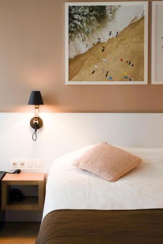 a bedroom with a bed and a picture of a beach at Alfa Inn in Blankenberge