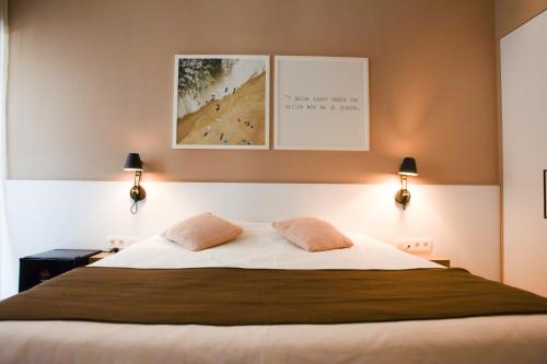 a bedroom with a large bed with two pillows at Alfa Inn in Blankenberge