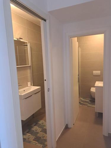 a white bathroom with a sink and a toilet at Villa Magica in Pirovac