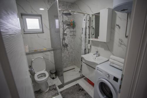 a bathroom with a toilet and a shower and a sink at Apartment LUX 2 in Tuzla
