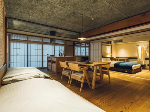 1 dormitorio con cama, escritorio y mesa en Showcase Hotel KASANE, en Gotsu