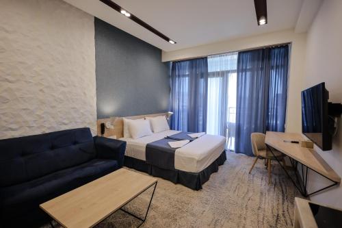 a hotel room with a bed and a couch at Rooftop Apart-Hotel in Yerevan