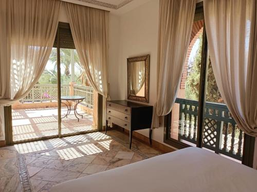a bedroom with a bed and a balcony at palmeraie village 2 in Marrakech