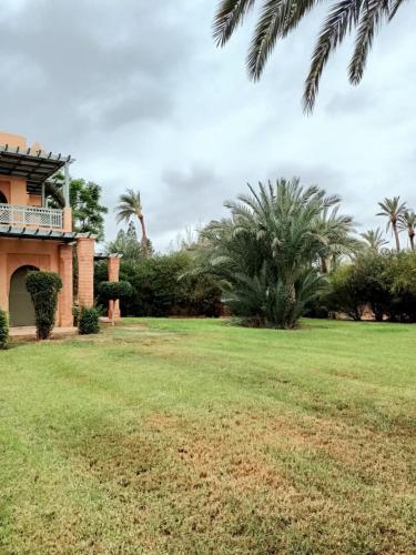 a yard with a house and palm trees at palmeraie village 2 in Marrakech