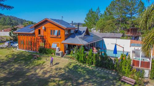 ein orangefarbenes Haus mit Sonnenkollektoren darüber in der Unterkunft Casa do Lago Pinhal in Rio dos Cedros