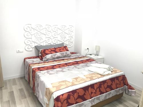 バレンシアにあるBorrullApartの白い壁のベッドルーム1室(ベッド1台付)