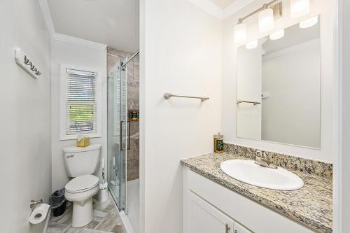 uma casa de banho branca com um WC e um lavatório em Sun Outdoors Chincoteague Bay em Chincoteague