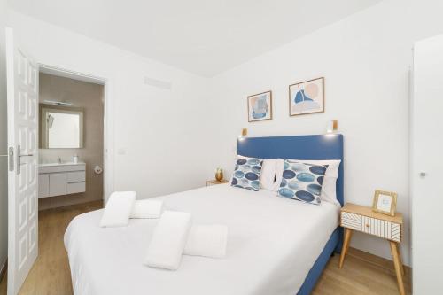 um quarto branco com uma cama azul e branca em Pátio C'un Casinhas em Nazaré