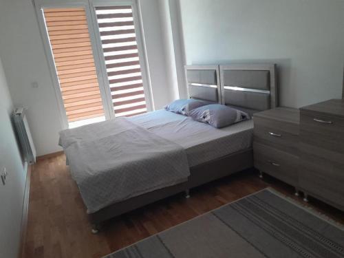 - une chambre avec un lit, une commode et 2 fenêtres dans l'établissement Luxsary Home in Skopje, à Skopje