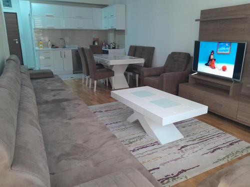 - un salon avec un canapé, une table et une télévision dans l'établissement Luxsary Home in Skopje, à Skopje