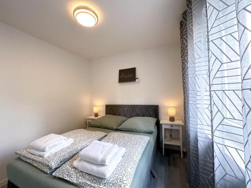 a bedroom with a bed with two towels on it at Stilvolles, frisch renoviertes 2Zi Apartment mit Küche und Balkon in Kliniknähe! in Bad Oeynhausen