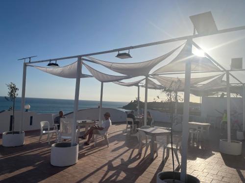 a patio with tables and chairs and a view of the ocean at Hotel Miramare Garzia in Marinella di Selinunte