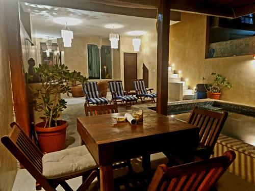 uma sala de jantar com uma mesa de madeira e cadeiras em Villas Bliss 18 em Ilha das Mulheres