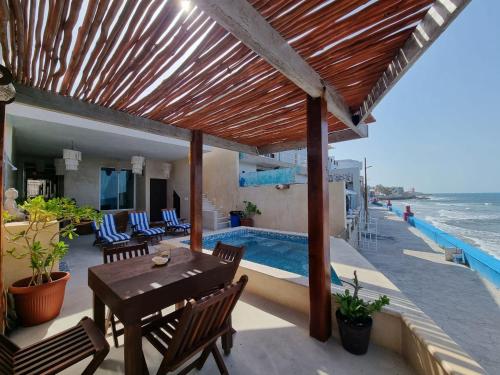 a patio with a table and chairs and a swimming pool at Villas Bliss 18 in Isla Mujeres