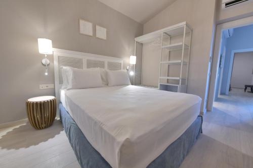 - une chambre avec un grand lit blanc et une étagère dans l'établissement Cocoon Elegant Living, à Gerakini