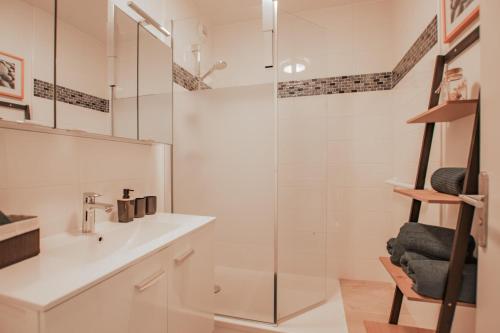 a bathroom with a glass shower and a sink at Appartement hyper centre avec garage privé in Concarneau