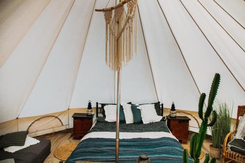 a bedroom with a bed in a tent at Wilcze Pole - tu odpoczniesz od świata in Postomino