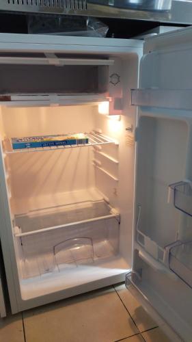 un réfrigérateur vide avec sa porte ouverte dans une cuisine dans l'établissement Josef appartment, à Paris