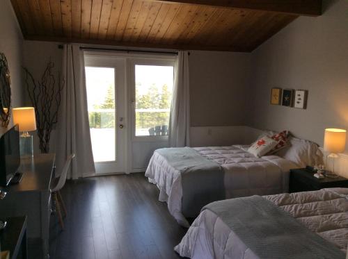 a bedroom with two beds and a sliding glass door at The Iona Heights Inn in Iona