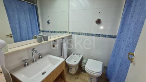 a bathroom with a sink and a toilet and a mirror at Dto Triskel con vista al lago in San Carlos de Bariloche