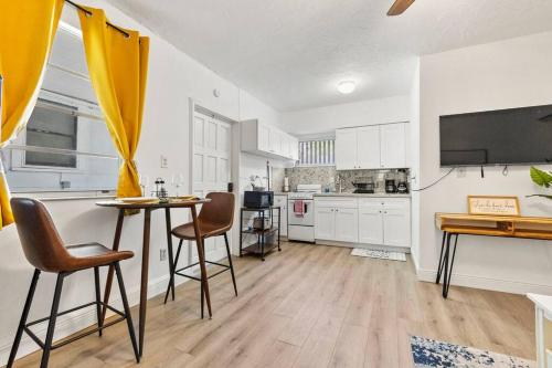 a kitchen with white cabinets and a table and chairs at Intimate Casita Mia minutes away from Airport, Calle 8, Brickell, Coral Gables, The beach and more! in Miami