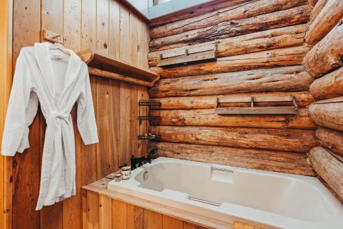 ein Badezimmer mit einer Badewanne und einer Holzwand in der Unterkunft Beautiful Log home outside of Sisters in Sisters