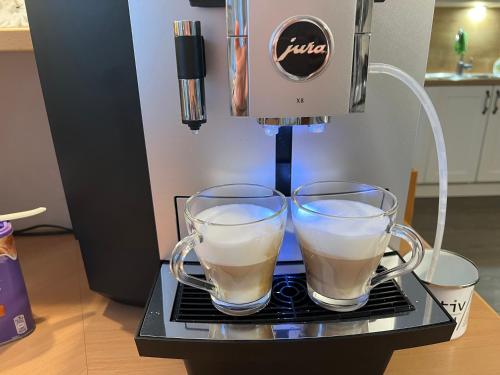 two glasses of coffee sitting on top of a coffee maker at Frühstückspension Gsenger in Ramsau am Dachstein