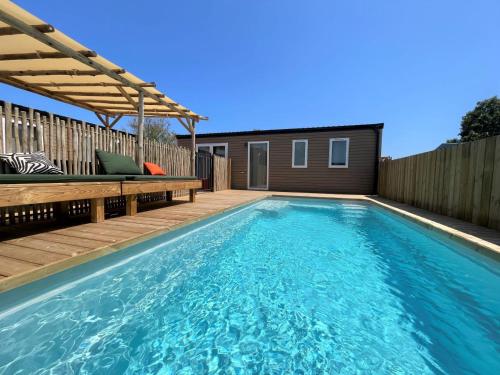 une piscine avec une terrasse et une maison dans l'établissement Camping La Clape Village, au Cap d'Agde