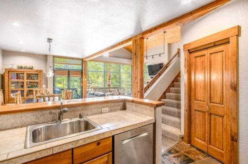 una cocina con fregadero y una escalera en Lovely Townhome A Half-mile From Keystone Gondola W-shared Hot-tub Excellent Views, en Dillon