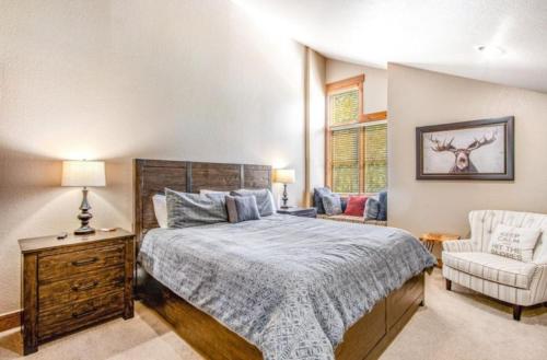 a bedroom with a large bed and a chair at Lovely Townhome A Half-mile From Keystone Gondola W-shared Hot-tub Excellent Views, in Dillon