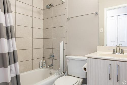 a bathroom with a toilet and a tub and a sink at The Avery in Atlanta