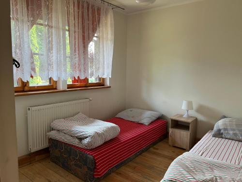 um quarto com 2 camas individuais e uma janela em Domki Carmen em Wierzchownia