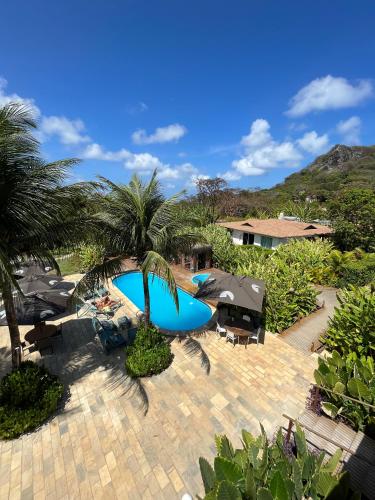 a patio with a blue pool and palm trees at Dolphin Hotel in Fernando de Noronha