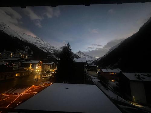a view of a town at night with snow at Zinal à 80m des remontées mécaniques in Zinal