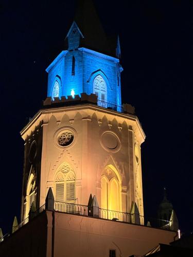een klokkentoren met 's nachts een blauw licht erop bij Brama Krakowska - Old Town - Premium Apartment in Lublin