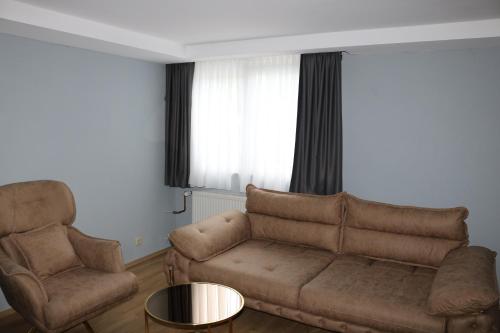 a living room with a couch and two chairs at Louis Hotels in Schmitten