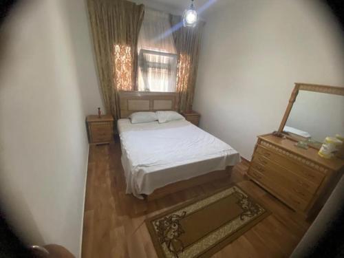 a small bedroom with a bed and a dresser at Appartement Corniche Nador in Nador