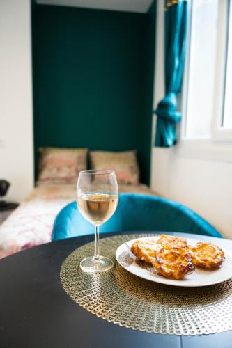 a glass of wine and a plate of food on a table at YELLOW HOME in Fougères