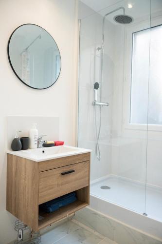 a bathroom with a sink and a shower with a mirror at YELLOW HOME in Fougères