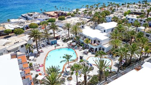 an aerial view of a resort with a pool and the ocean at Labranda Playa Club in Puerto del Carmen