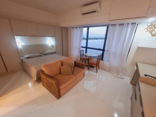 a bedroom with a bed and a chair and a table at Tropical Executive Vista Ponta Negra in Manaus