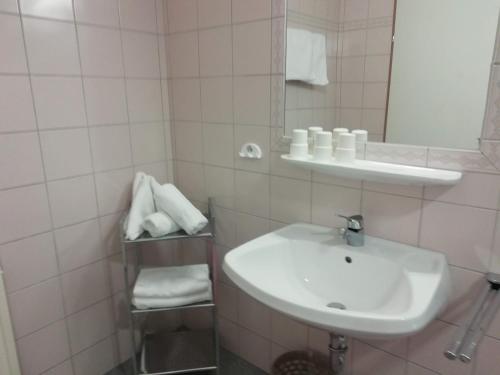 een witte badkamer met een wastafel en een spiegel bij Apart Studio Bergdiamant in Piösmes