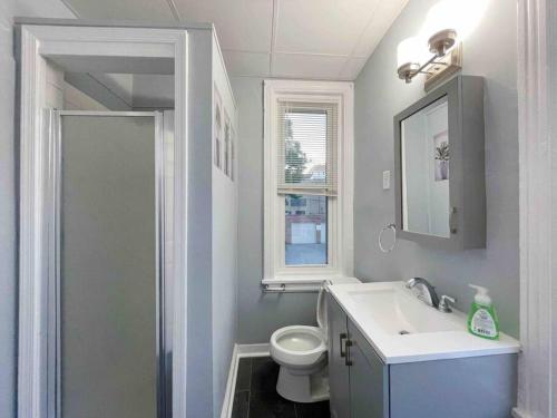 a bathroom with a sink and a toilet and a window at THE ECO HOME. Entire place with private parking in Wilmington